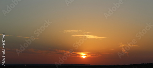 Bright orange sunrise coming over the hills and valley floor in West Texas