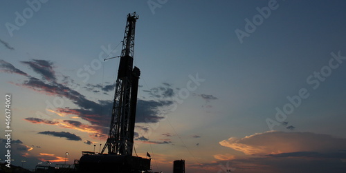 Beautiful sunset going over an oil and gas drilling rig in West Texas Permain Basin photo