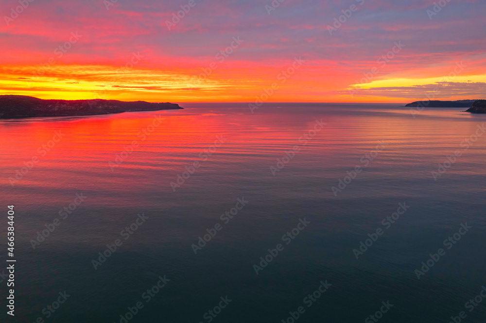 One hundred percent colourful cloud covered sunrise over the sea