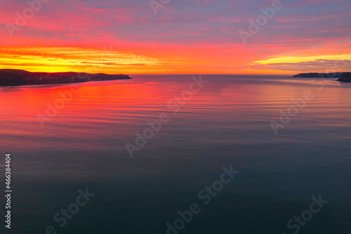 One hundred percent colourful cloud covered sunrise over the sea © Merrillie