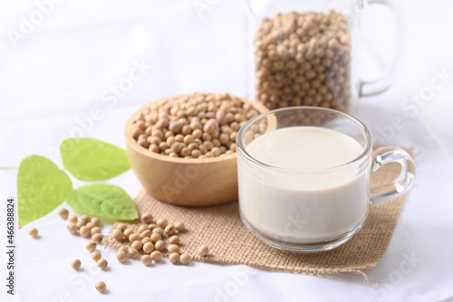 Soy milk in a cup glass and soy beans in a bowl on white background, Healthy drink