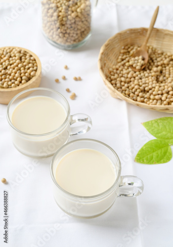 Soy milk in a cup glass and soy beans in a bamboo basket and bowl on white background, Healthy drink