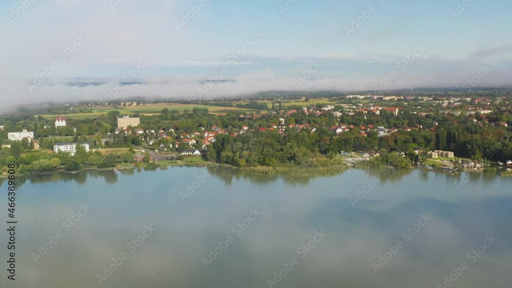 Drone shot through the clouds revealing Kezthely in Hungary Drone shot through the clouds revealing Kezthely in Hungary