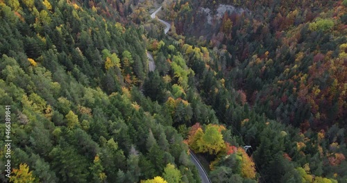Aerial footage over pyrenees mountain forest and road in autumn in north Spain during sunset
