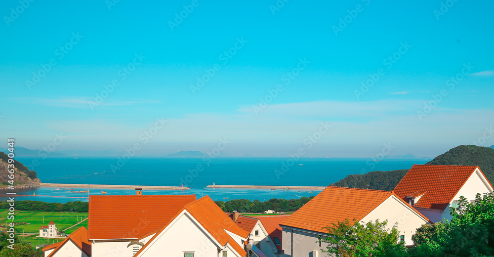건물 사이로 보이는 남해 독일 마을의 푸른 바다