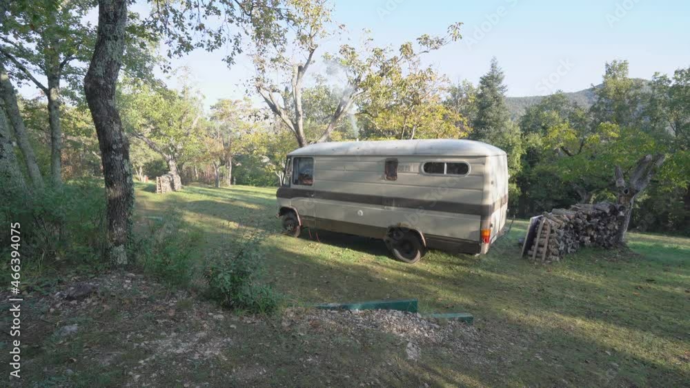 Old Camper On A Camping pitch with Smoke Coming Out From Heating System Chimney Old Camper On A Camping pitch with Smoke Coming Out From Heating System Chimney