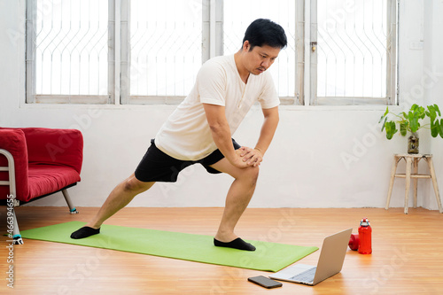 man having rest taking a break after training, sitting on floor at home