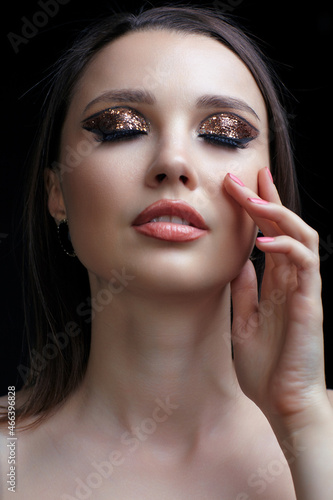 Beautiful young woman portrait with vogue shining face makeup an