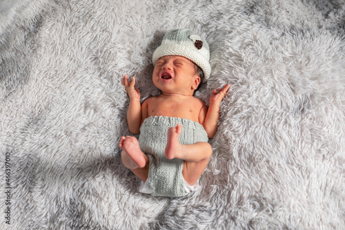 Top view happy newborn baby lying sleeps on a white blanket raise hands up comfortable and safety.Cute Asian newborn sleeping and napping crying on bed.Newborn Baby photography concept