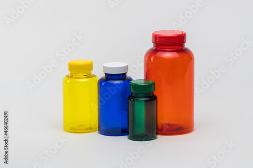 Multi colored transparent plastic pill jars on a white background. Isolated