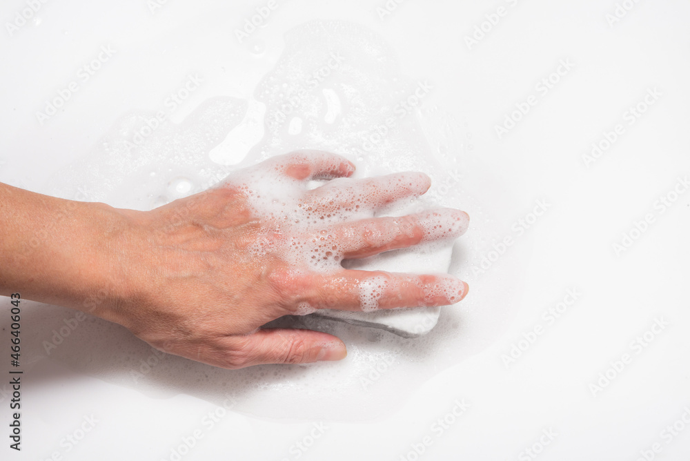 Hand with foam holding sponge, cleaning white surface Hand with foam holding sponge, cleaning white surface