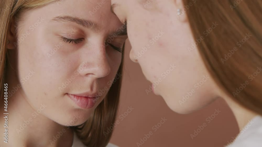 Tracking extreme close up shot of young twin girls touching their foreheads and standing with their eyes closed Tracking extreme close up shot of young twin girls touching their foreheads and standing with their eyes closed