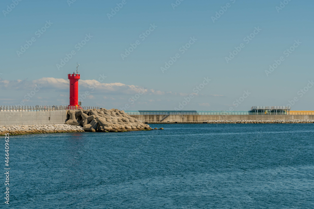 Red lighthouse on concrete pier