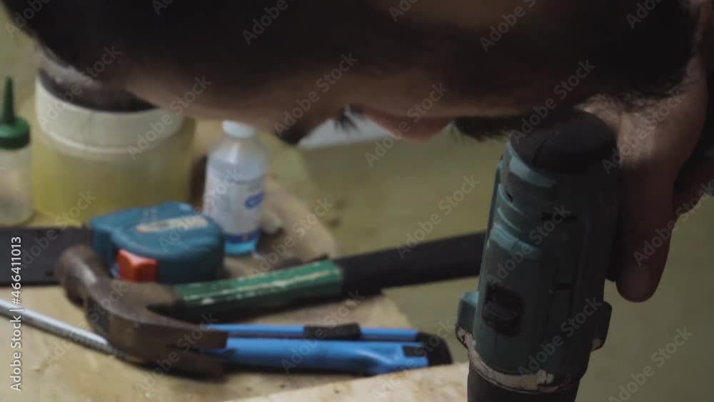 Skateboard Maker Drilling Holes On Wood Plank Using A Cordless Driller. close up, tilt down Skateboard Maker Drilling Holes On Wood Plank Using A Cordless Driller. close up, tilt down