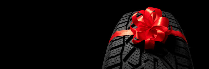 black isolation rubber tire, on the grey backgrounds in a bow for christmas