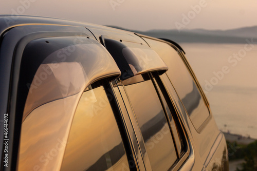 Reflection of a mountain lake in the windows of an SUV