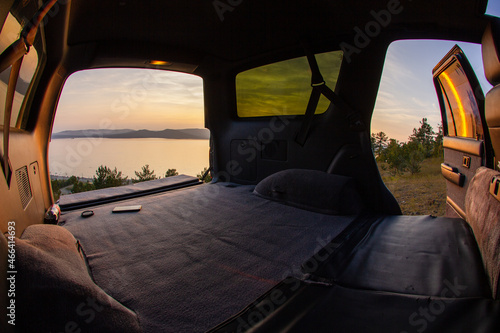 View of the sunset on a mountain lake from the cockpit of an SUV