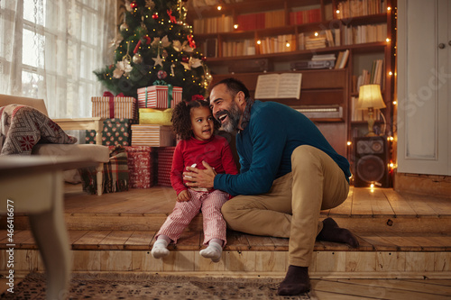 Mixed race father and daughter celebrating winter holidays at home