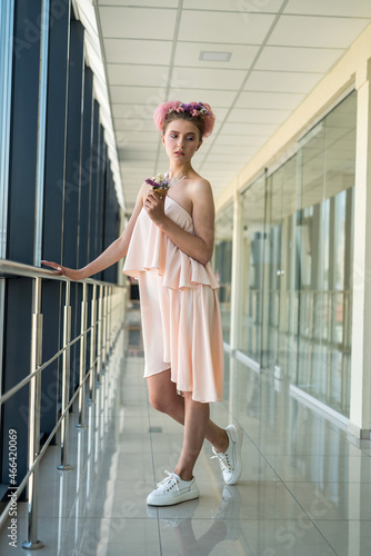 romantic woman posing in corridor wearing pink dress