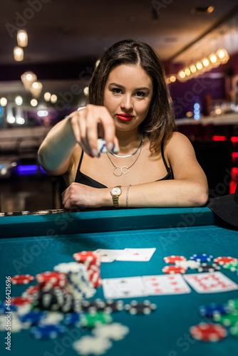 lucky pretty woman playing poker at green casino table