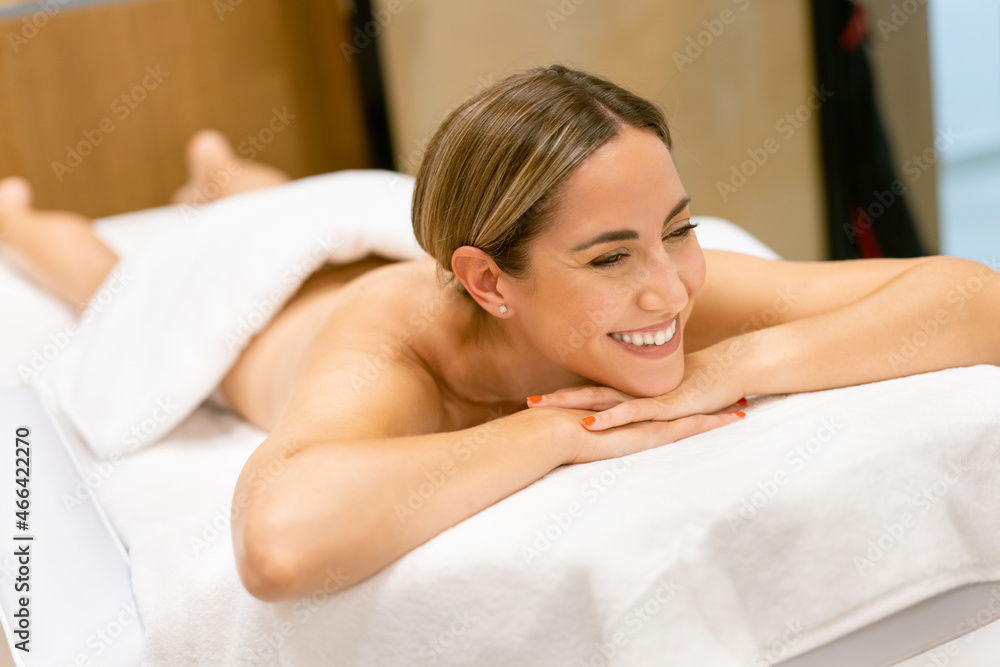 Middle-aged woman lying on a beauty parlour couch for a relaxing massage. Middle-aged woman lying on a beauty parlour couch for a relaxing massage.