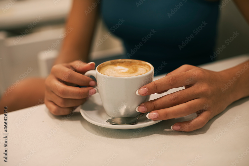 Young woman with manicured nails having coffee at cafe Young woman with manicured nails having coffee at cafe