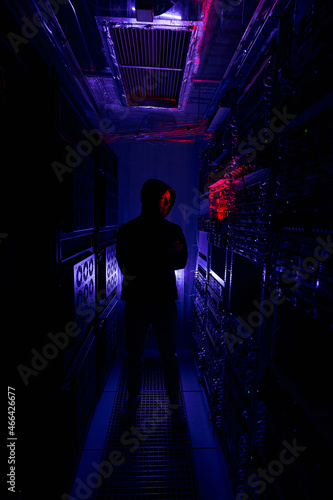 Man standing before computer equipment racks in data center