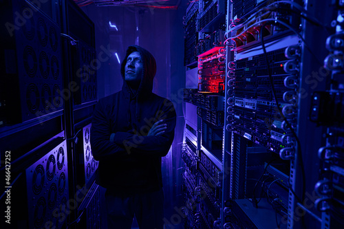 Serious data center intruder examining network equipment photo