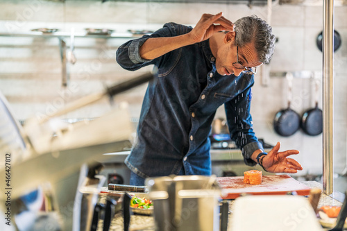 Male chef seasoning food in kitchen