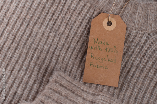 Label made with recycled fabric and decorated with a Christmas tree branch. Ecological and sustainable fashion.