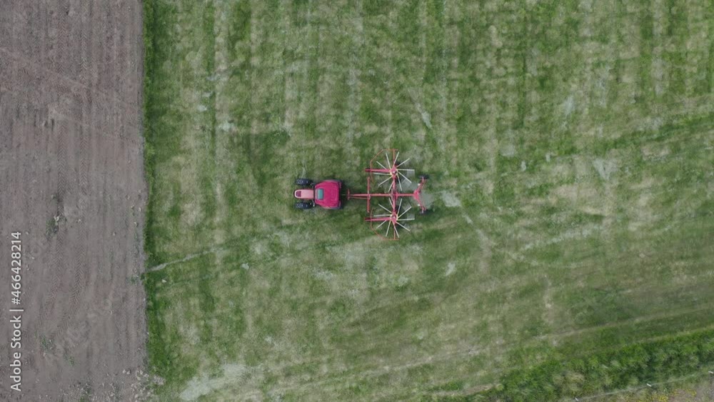 Tractor with spinning silage machine parked on green rural field in Iceland Tractor with spinning silage machine parked on green rural field in Iceland