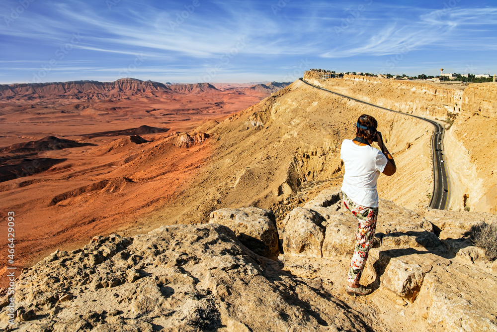 Woman photographing on a steep cliff