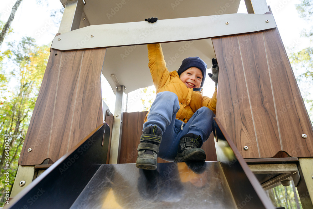 Happy boy playing on slide at park Happy boy playing on slide at park