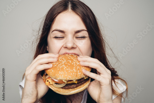 woman with a hamburger in her hands a snack fast food close-up