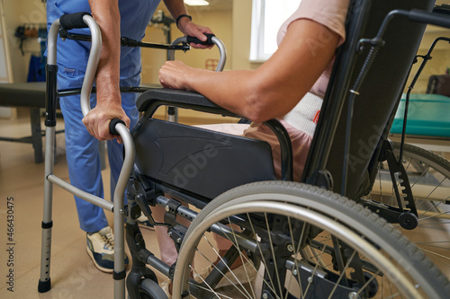 Stroke woman uses walker for support in rehab center