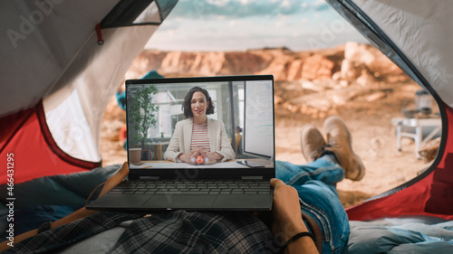 POV of a Tourist Making a Video Call with a Friend or a Colleague on Laptop Computer. Traveller Resting in a Tent on Top of a Rocky Mountain. Adventurous Hiker Living in Nature.