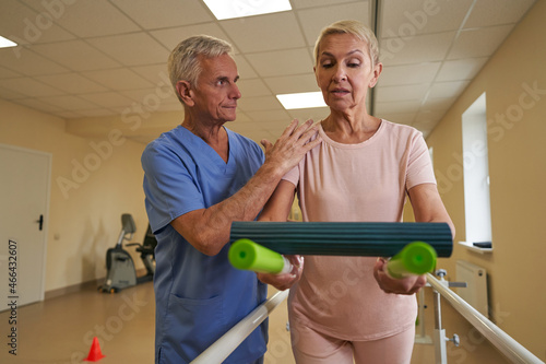 Caucasian woman doing exercises with motoric training equipment in clinic photo