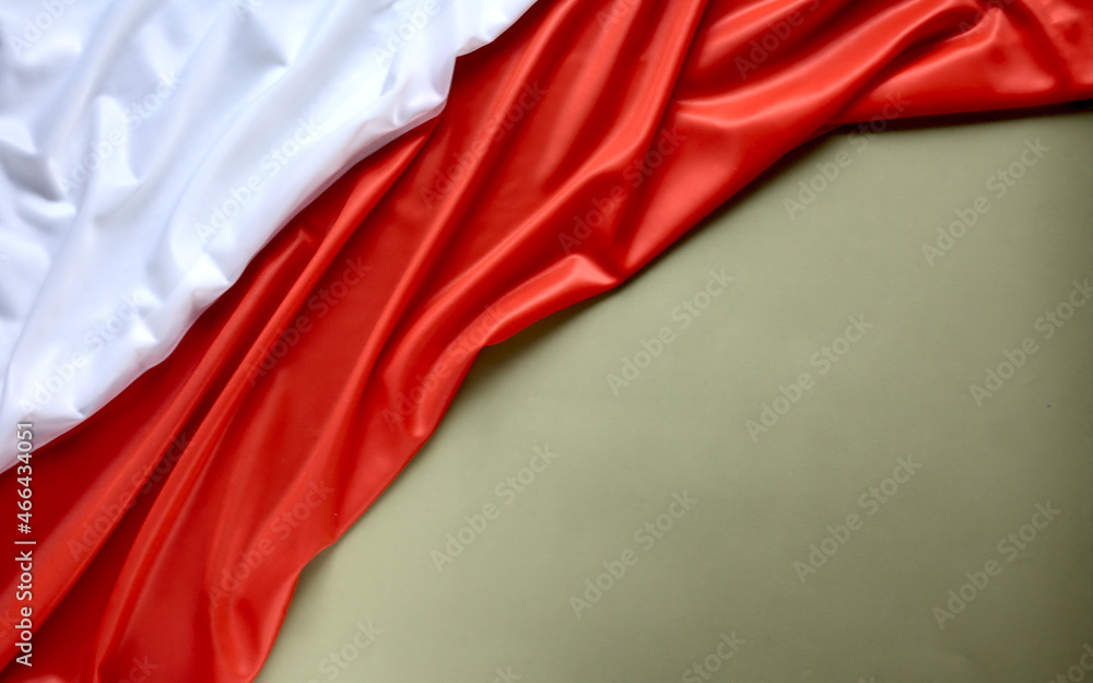 Polish flag on a green (olive) background, copy space. Independence Day November 11, Poland.