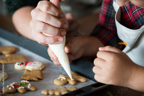 Boy making gingerbread cookies with his mum photo