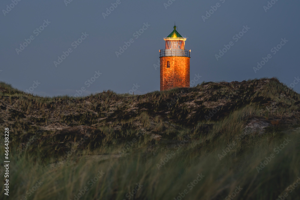 Grassy cliffside with Rotes Kliff Lighthouse in background Grassy cliffside with Rotes Kliff Lighthouse in background