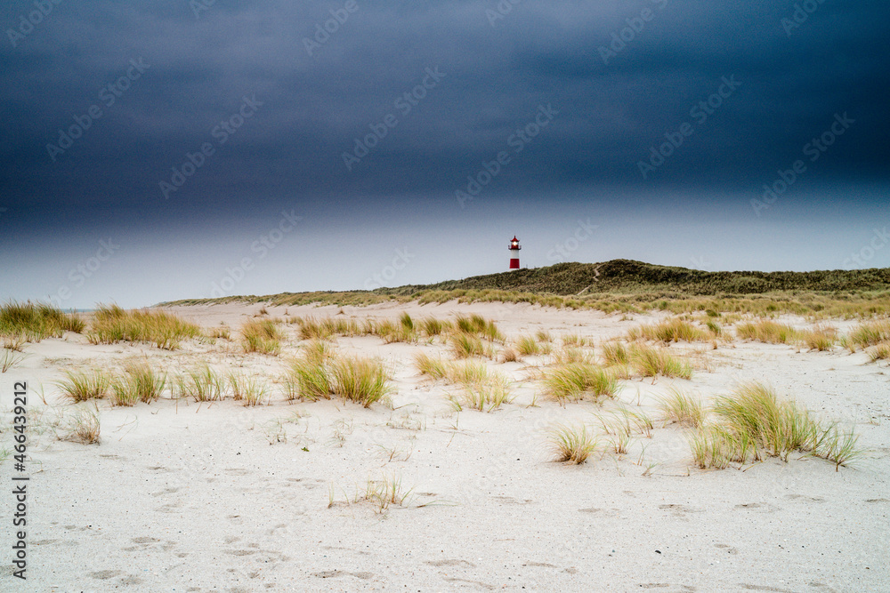 Lighthouse at the North Sea in a beach landscape with sand dunes