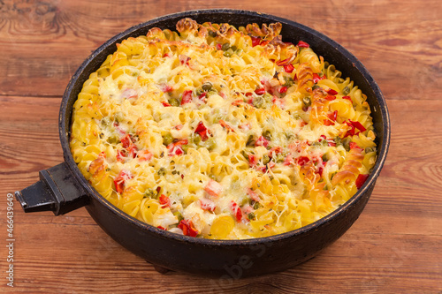 Casserole with pasta and vegetables in pan on rustic table