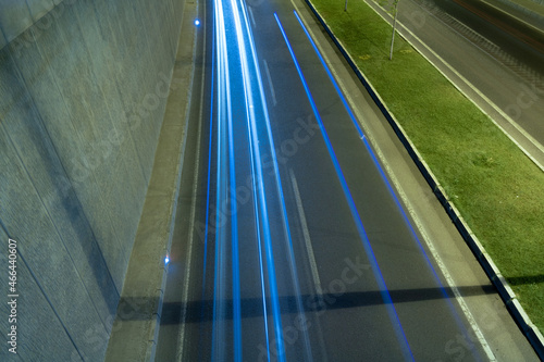 Light trails on the underpass road at night. Traffic or highway background photo.