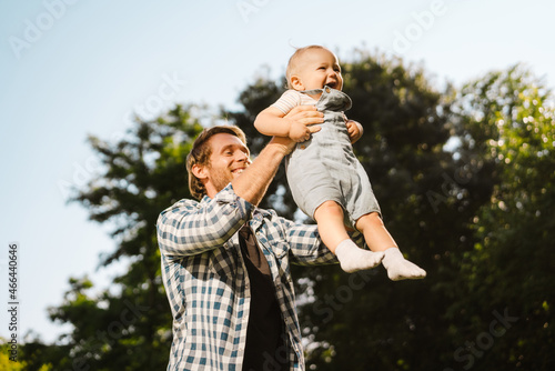 Happy mid aged father playing with his little baby son