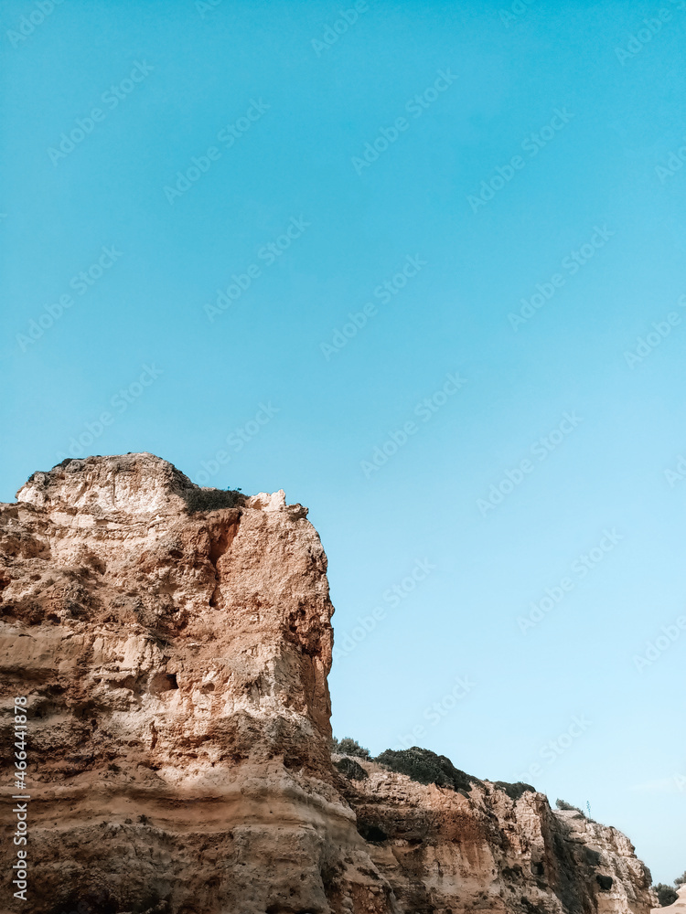 Huge arid and high rock on the blue sky