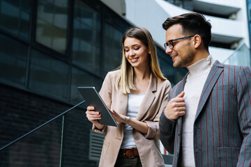 Two creative business people working on social media strategy using a digital tablet