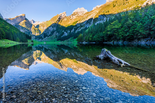 Mountains reflecting in clear water of Seealpsee lake at dawn photo