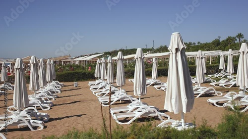 Empty sunny sandy beach and traditional beach equipment for convinient and safe relaxing and sunbathing photo