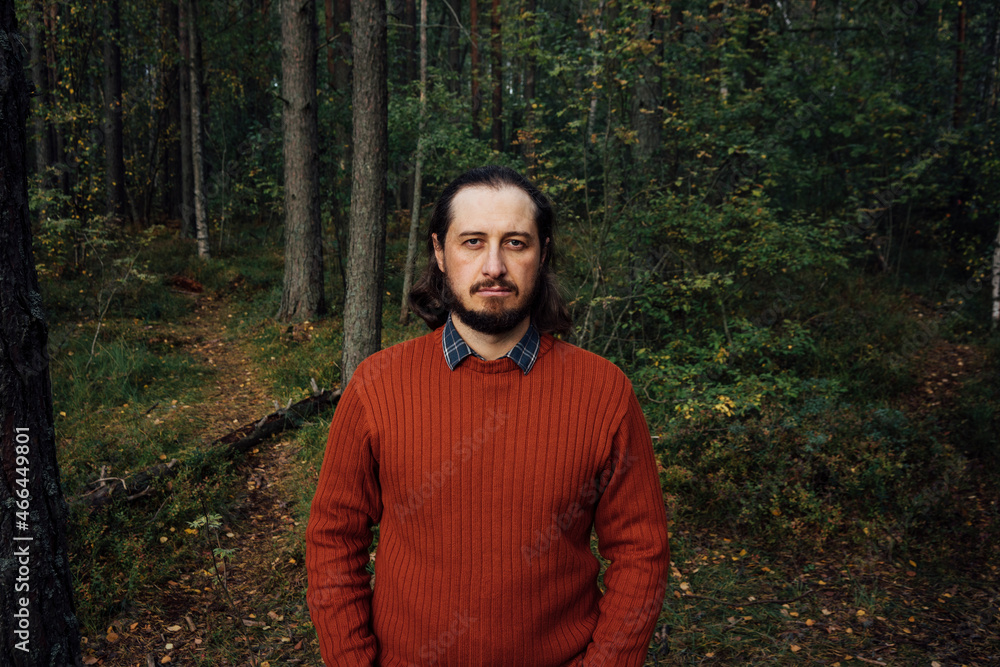 Serious man standing in forest Serious man standing in forest