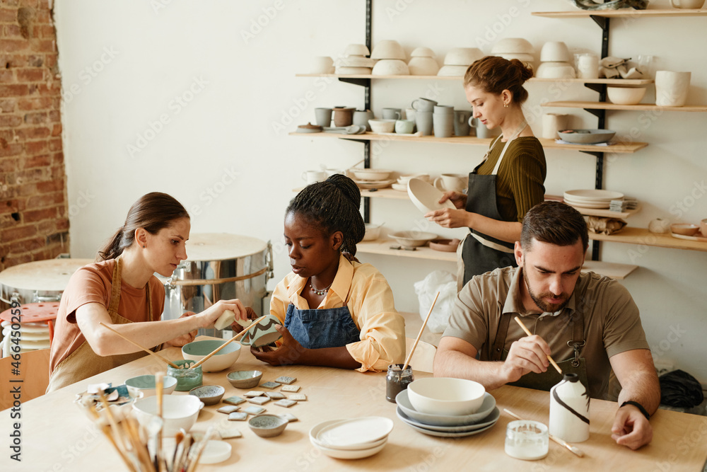 Warm toned portrait of diverse group of people enjoying pottery workshop in cozy studio - obrazy, fototapety, plakaty 